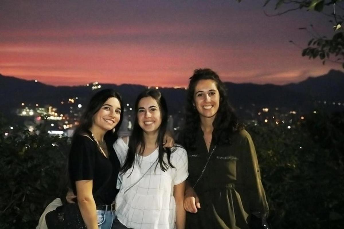 a group of three women posing for a picture at night