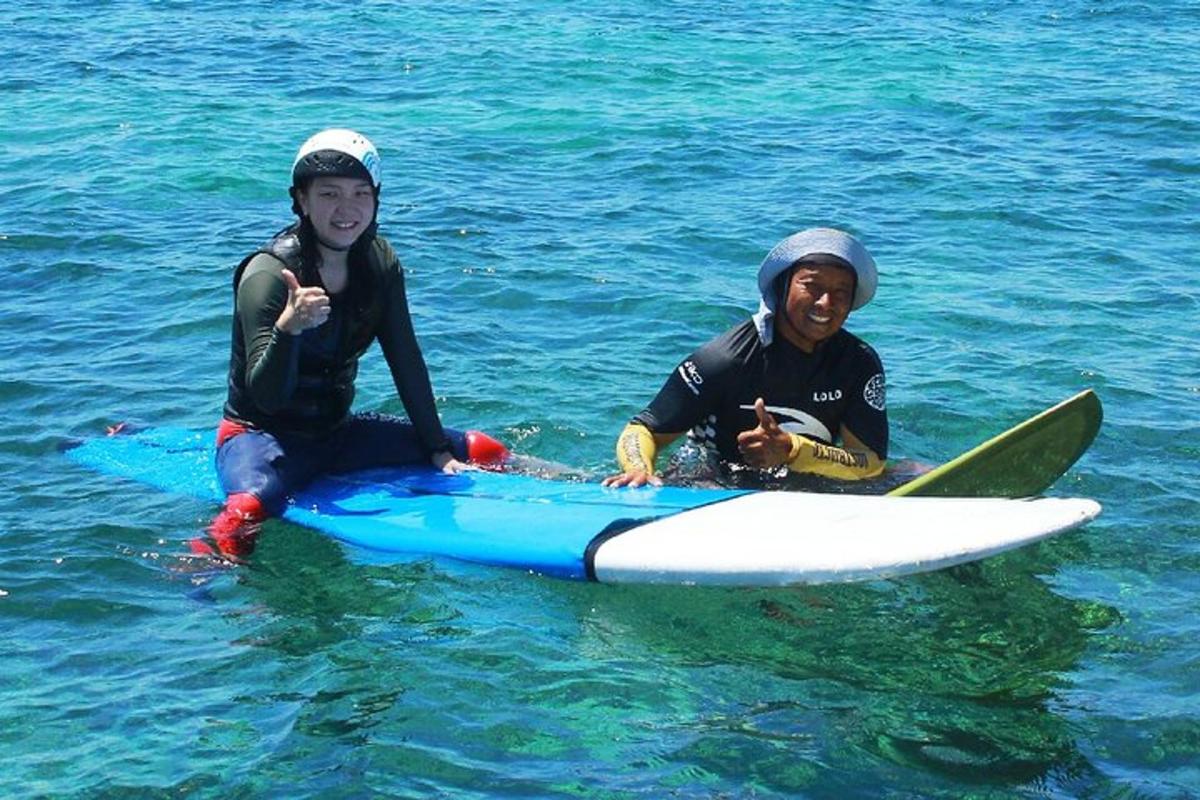 dua lelaki sedang duduk di atas papan luncur di dalam air