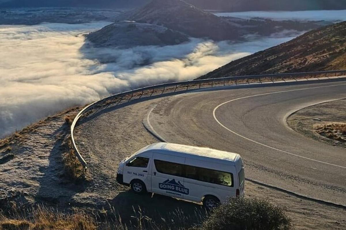 uma van branca dirigindo por uma estrada com nuvens