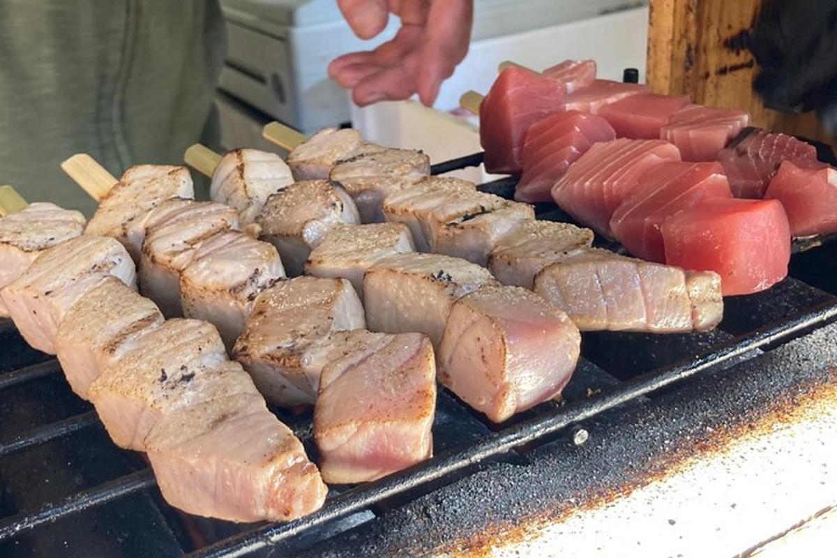 uma grelha com carne e outros alimentos