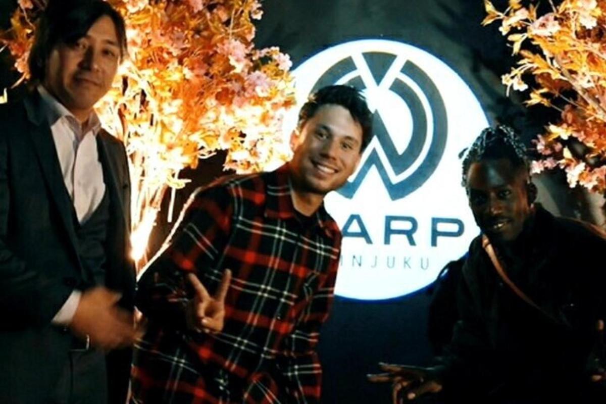 a man in a plaid shirt standing next to two men