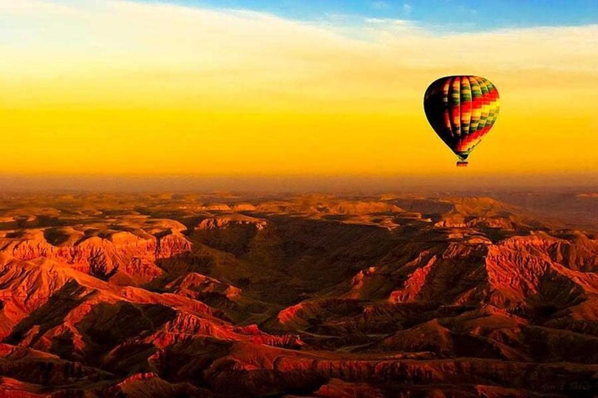 a hot air balloon flying over a mountain range