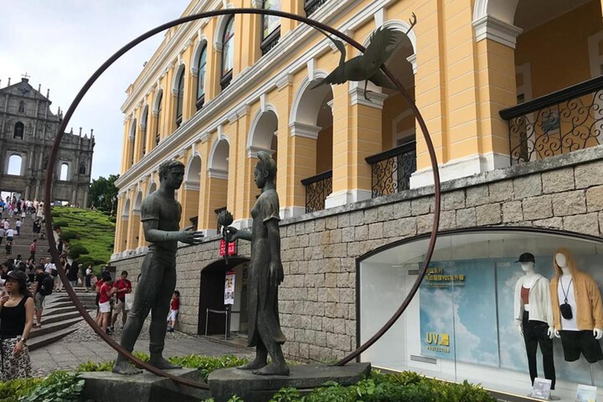 a statue of three men standing next to a building
