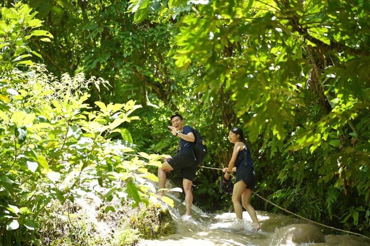 un homme et une femme sur une corde traversant une rivière