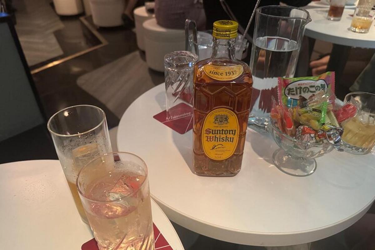 bílý stůl s lahví alkoholu a sklenicemi
