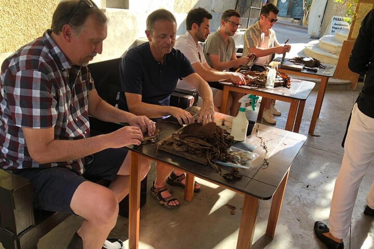 Un grupo de hombres sentados alrededor de una mesa comiendo pastel.