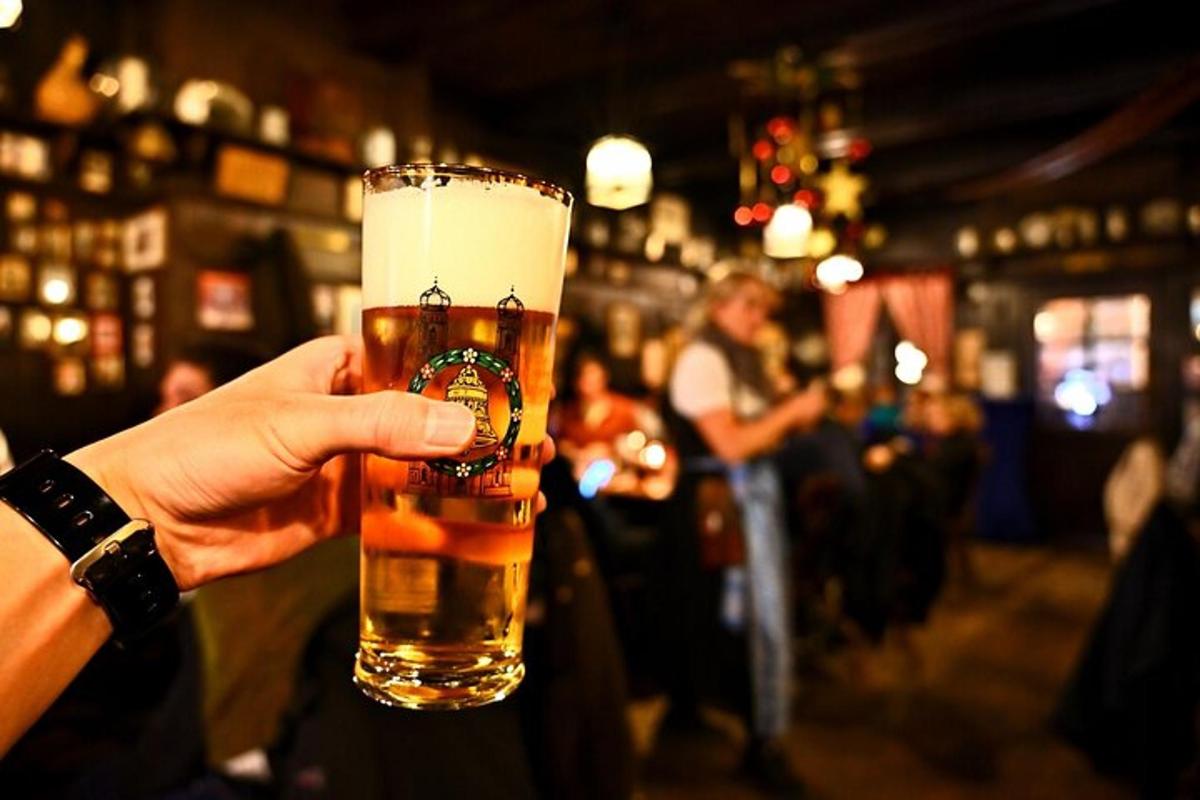 maður heldur á bjórglasi á bar