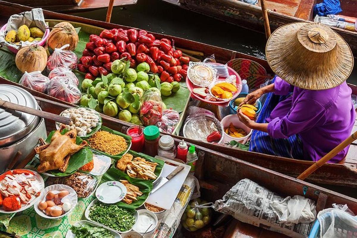 una donna su una barca piena di frutta e verdura