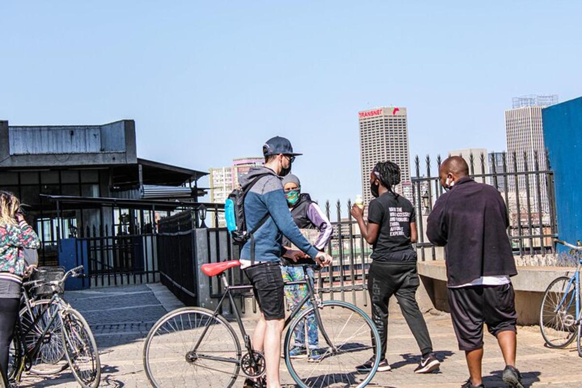 a group of people standing with bikes on a bridge