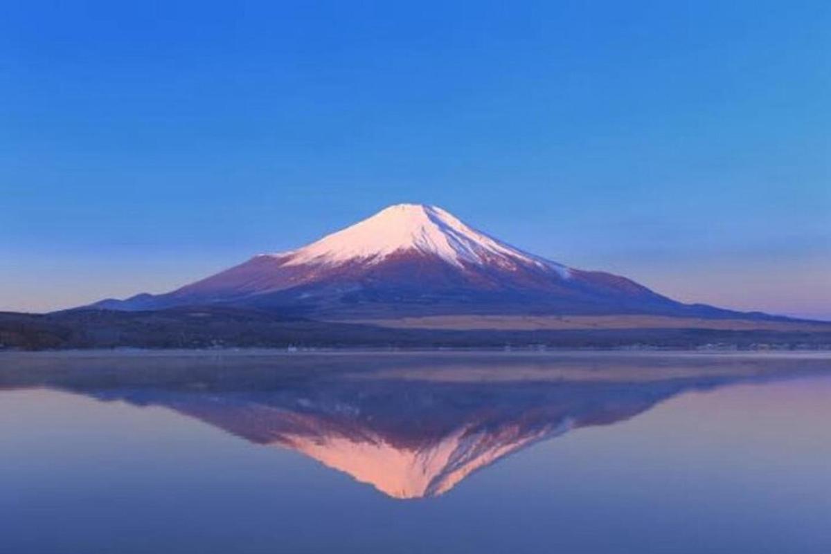 uma montanha com seu reflexo em um corpo d'água