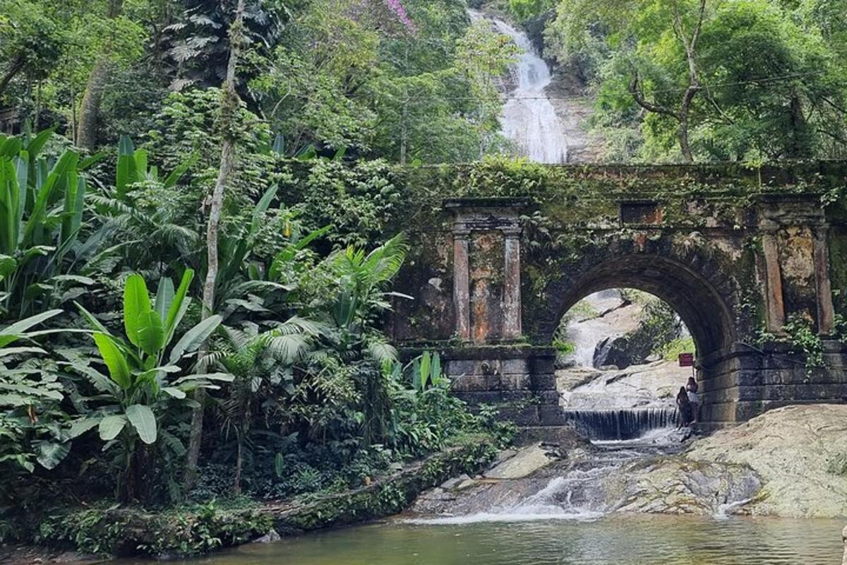 un vecchio ponte sopra un fiume con una cascata