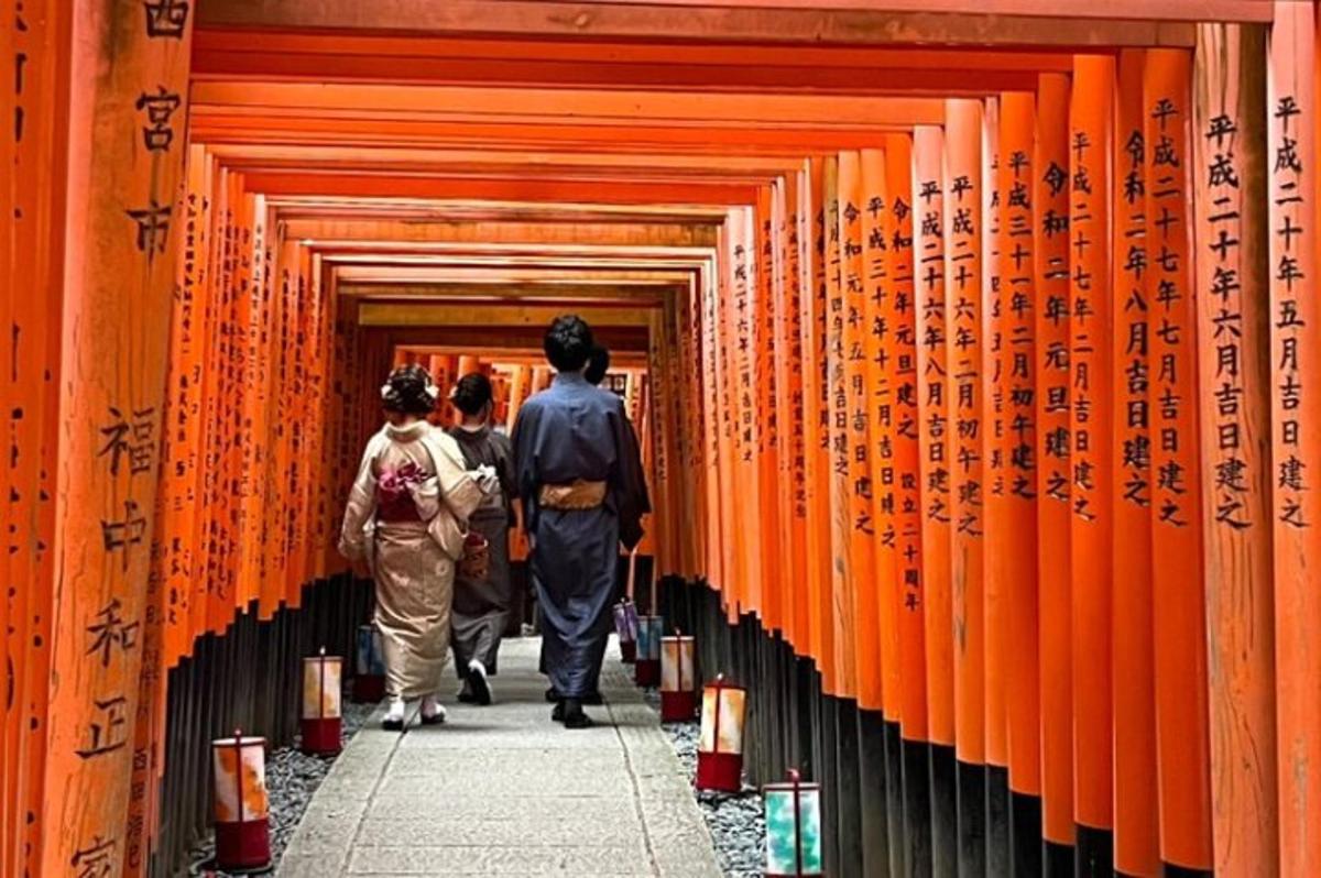 ljudje, ki hodijo skozi hodnik oranžnih torii vrat