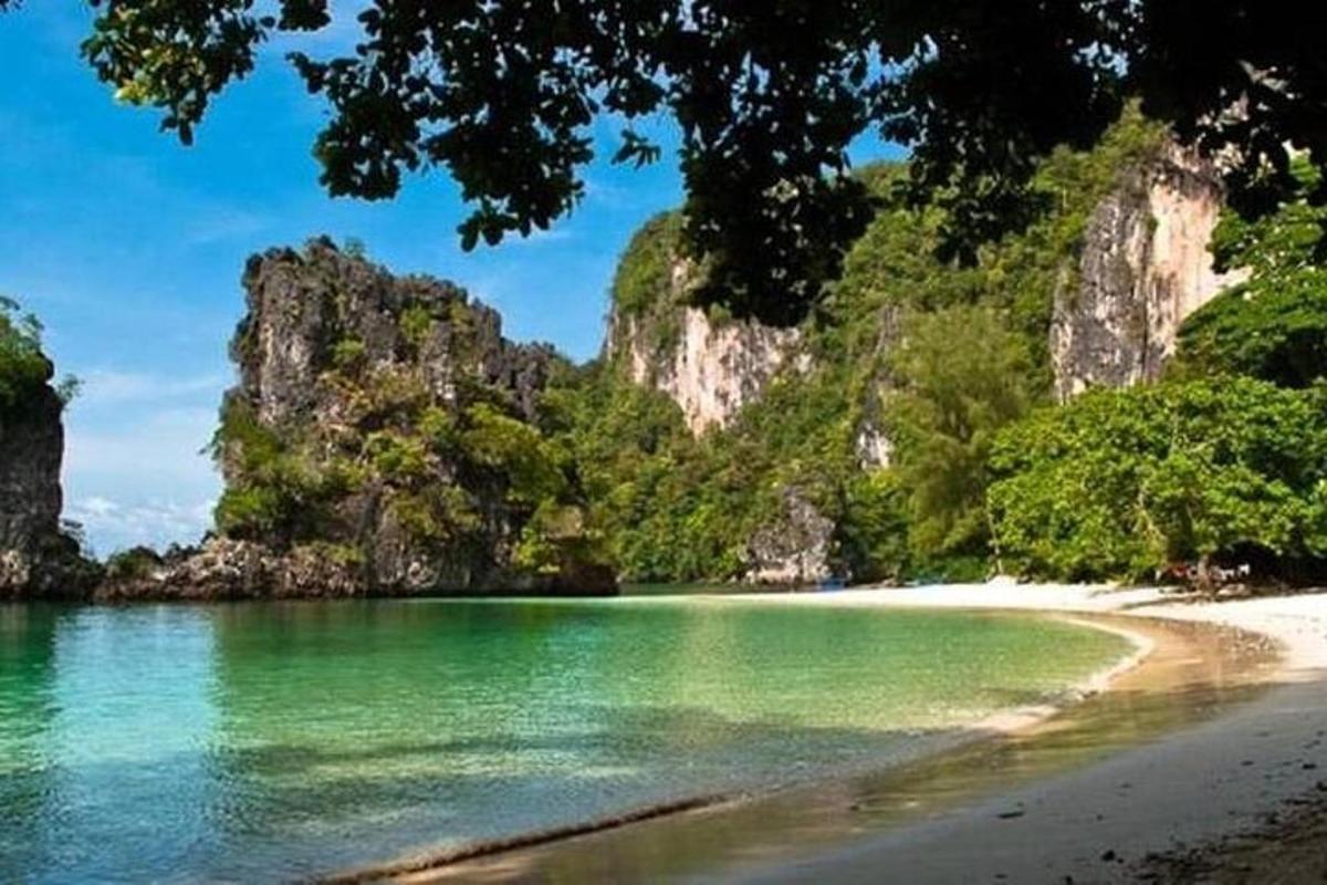 pantai dengan air hijau dan tebing batu kapur
