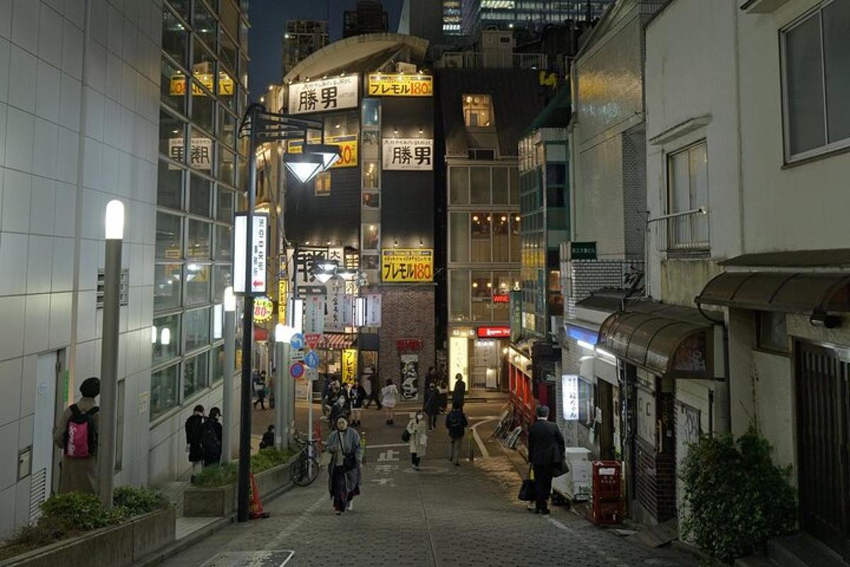 um grupo de pessoas caminhando por uma rua da cidade à noite