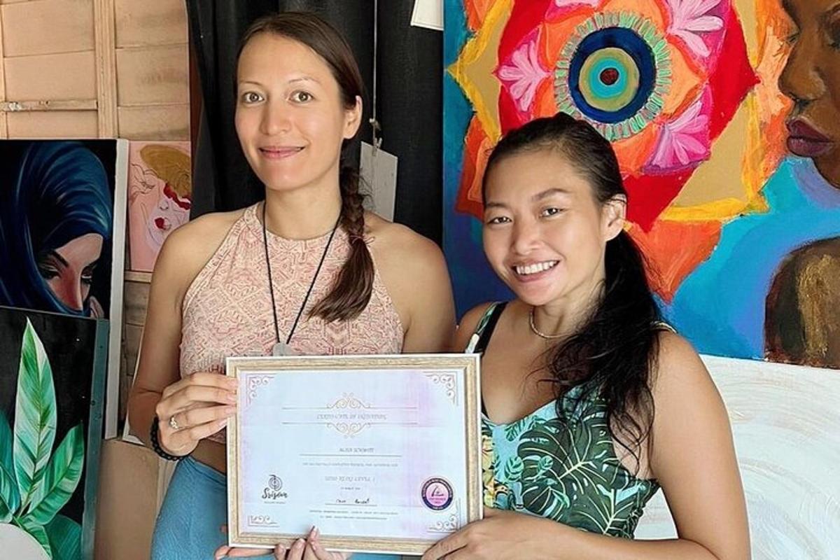Dvě ženy drží certifikát před obrazem