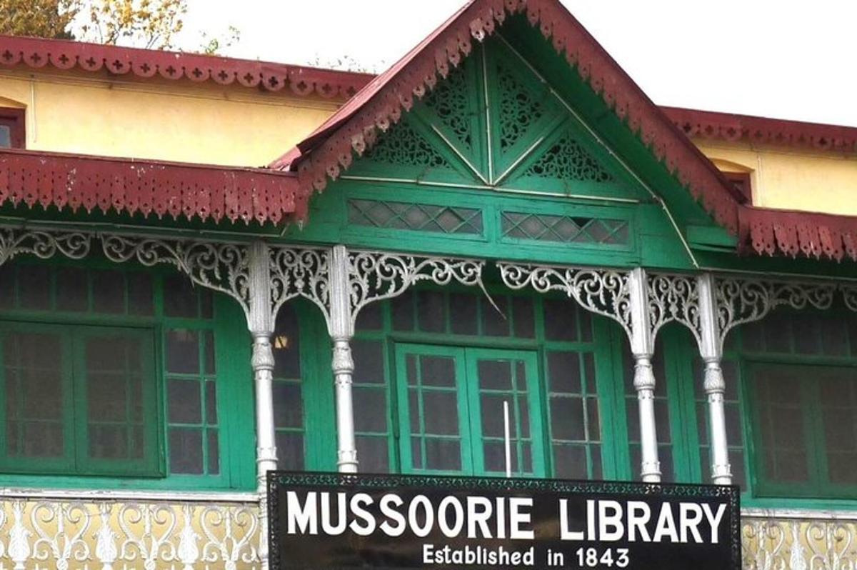 a green and white building with a sign in front