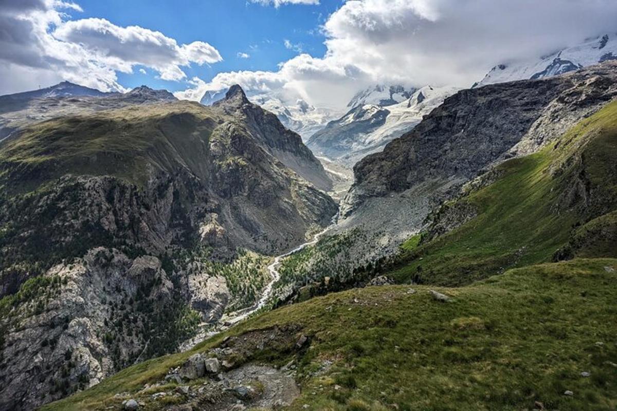 a view of a mountain valley with snow capped mountains