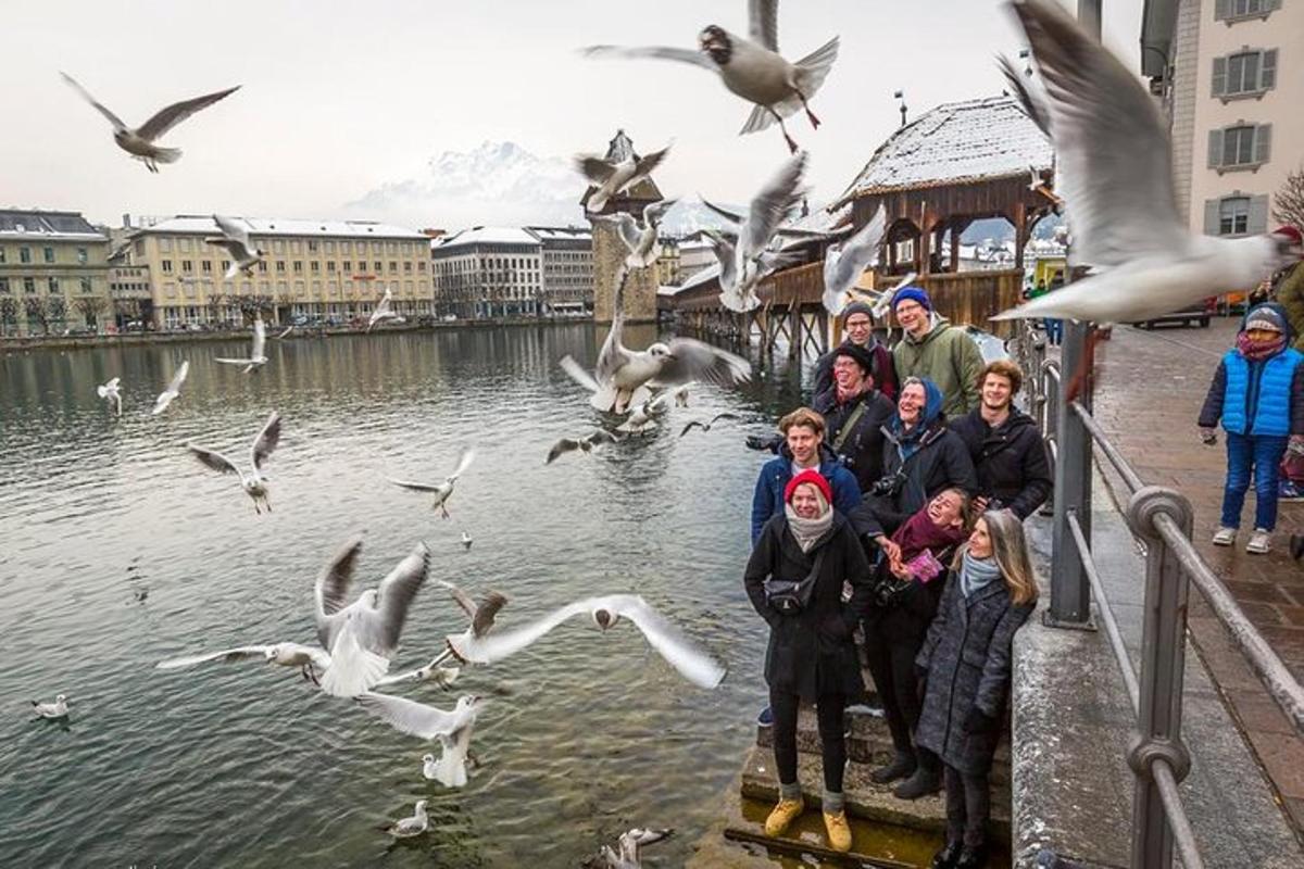 un gruppo di persone in piedi nell'acqua con gli uccelli