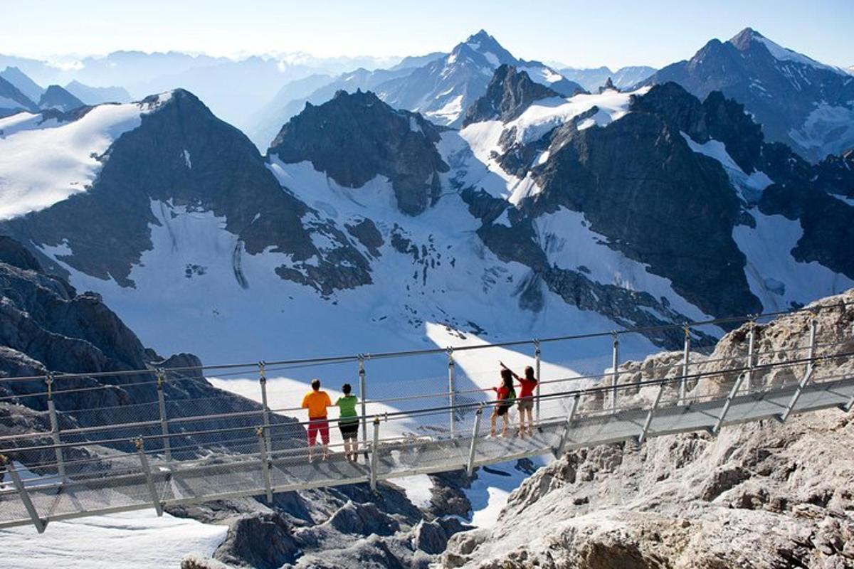 a group of people on a suspension bridge on a mountain