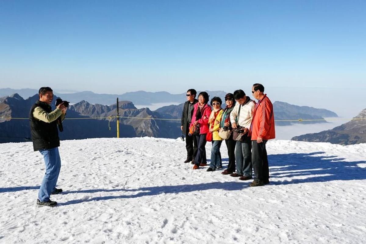 um homem tirando uma foto de um grupo de pessoas em uma montanha