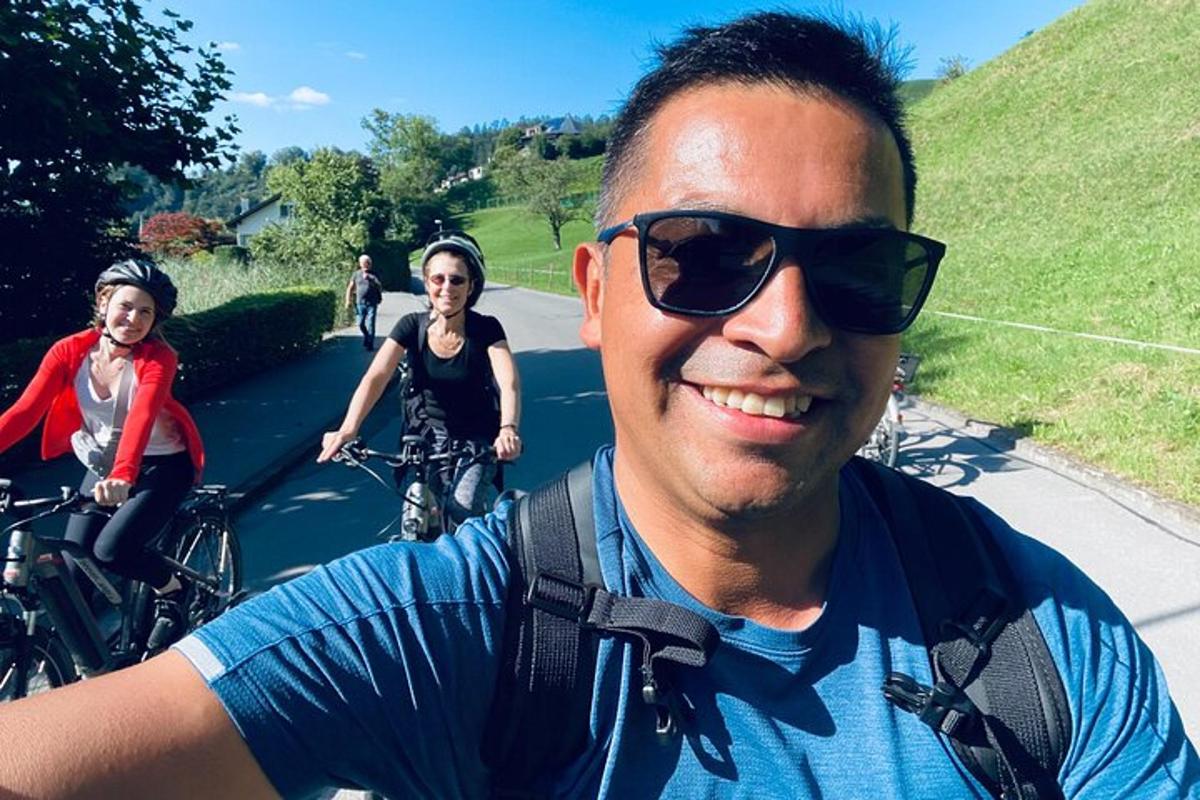 a man and two women riding bikes down a street