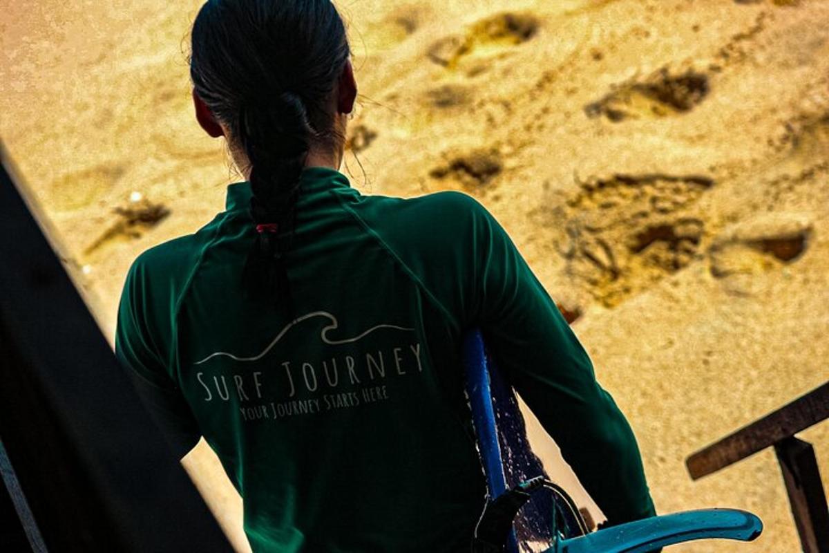 a woman in a green shirt standing at the beach