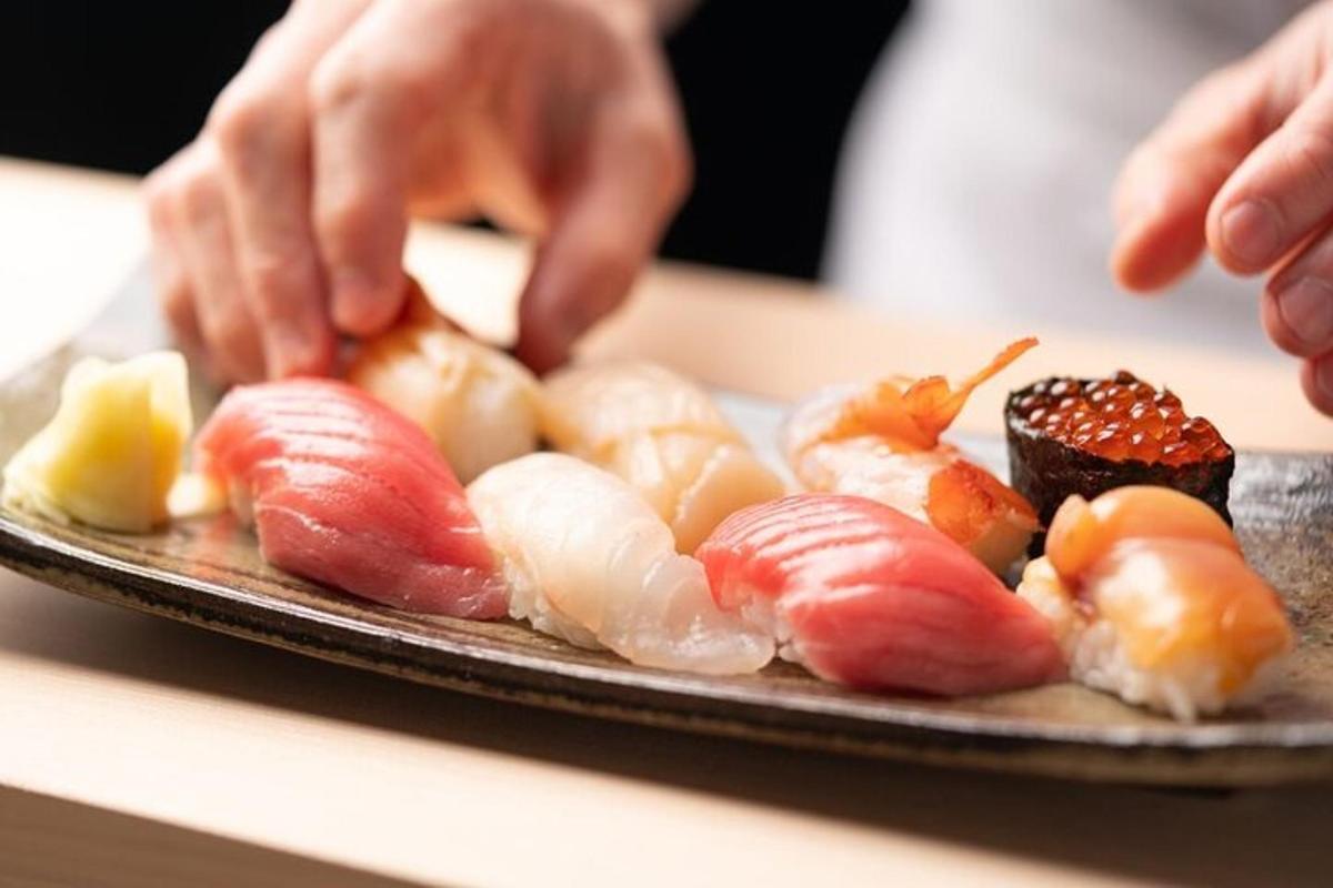 a person is preparing sushi on a plate