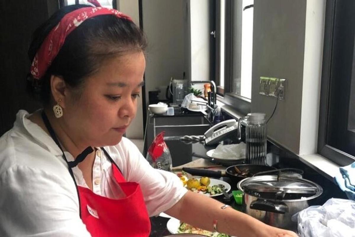isang babaeng nakatayo sa kusina na naghahanda ng pagkain