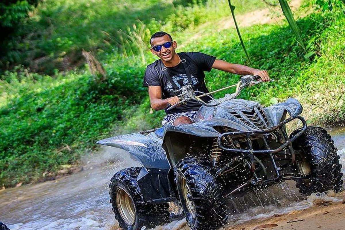seorang lelaki yang menaiki kenderaan empat roda di dalam lumpur