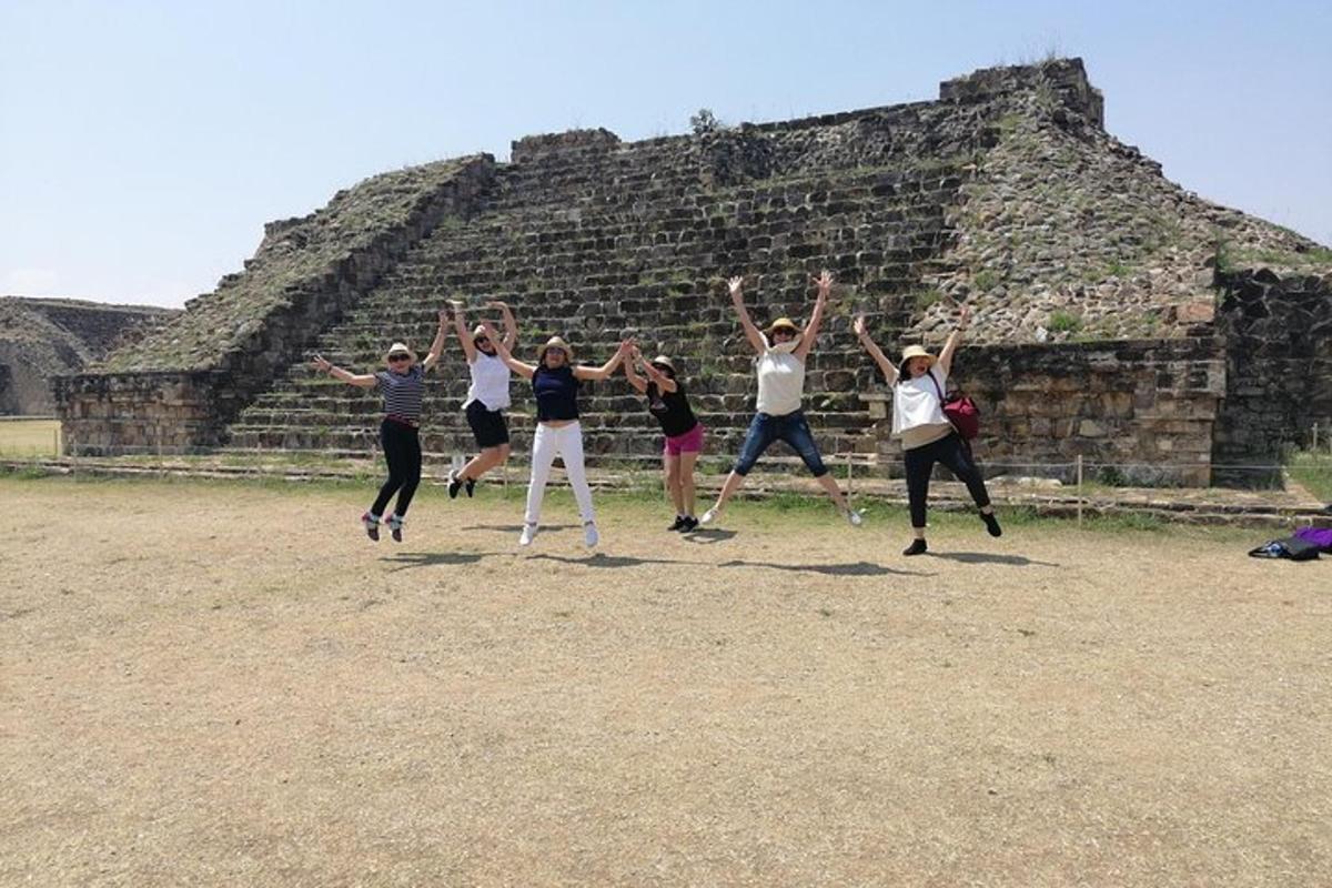 a group of people jumping in front of a pyramid