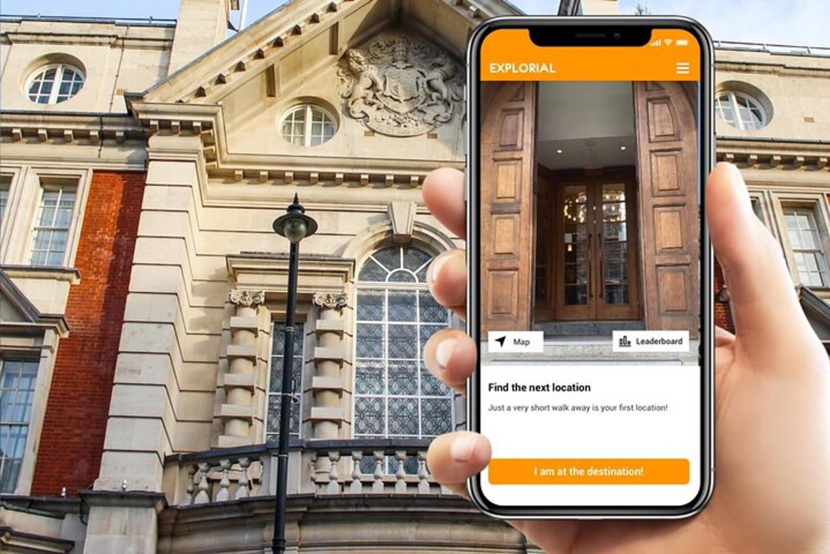 osoba držící mobilní telefon před budovou