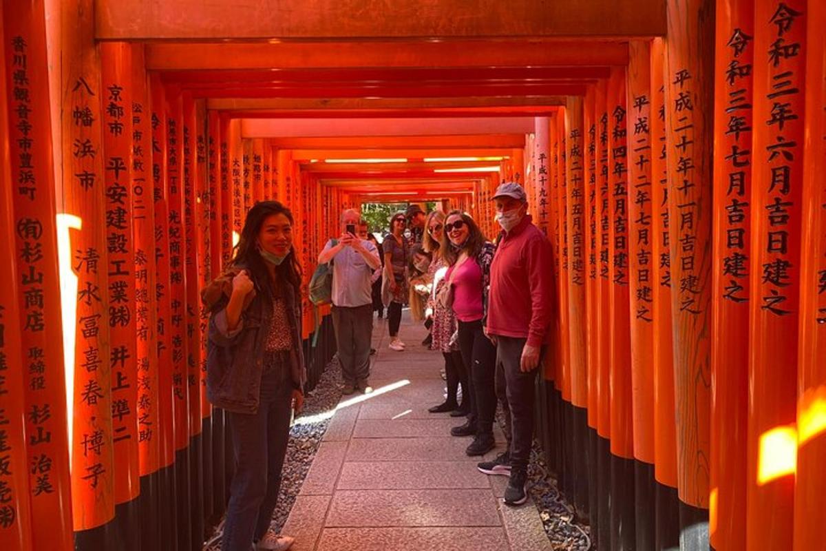 um grupo de pessoas caminhando por um túnel de portões laranja