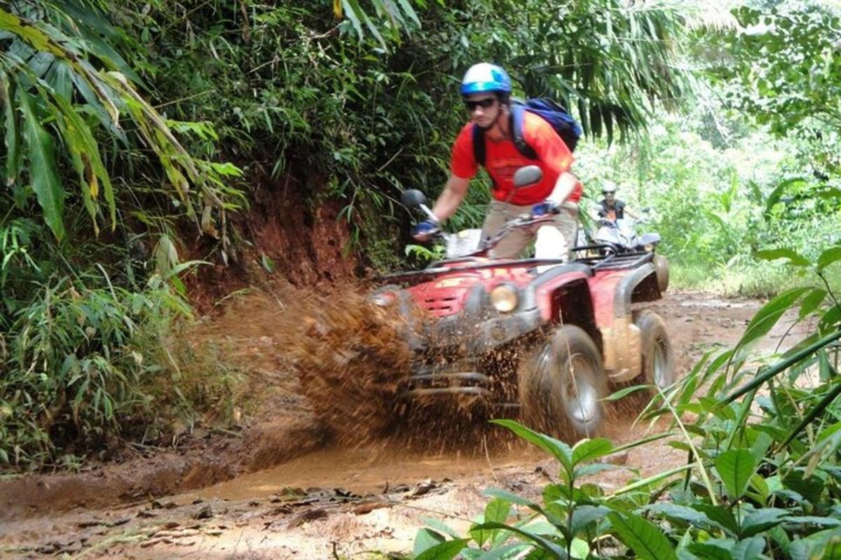 un uomo che guida un quad nello sporco