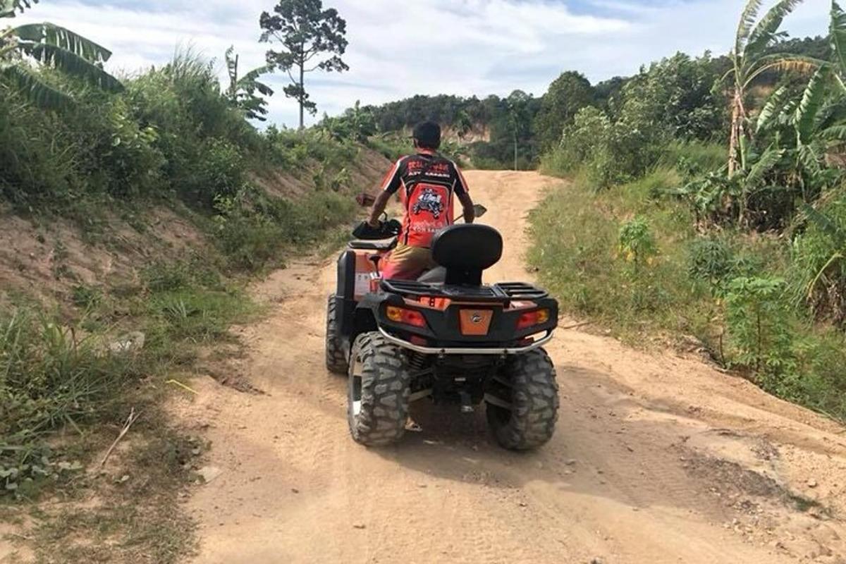 un uomo in sella a un quad su una strada sterrata