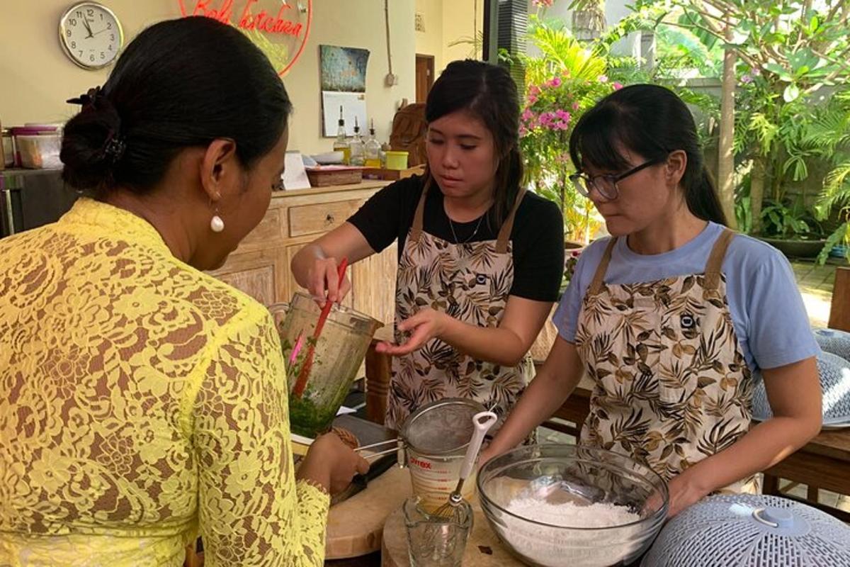 drie vrouwen staan in een keuken en bereiden eten