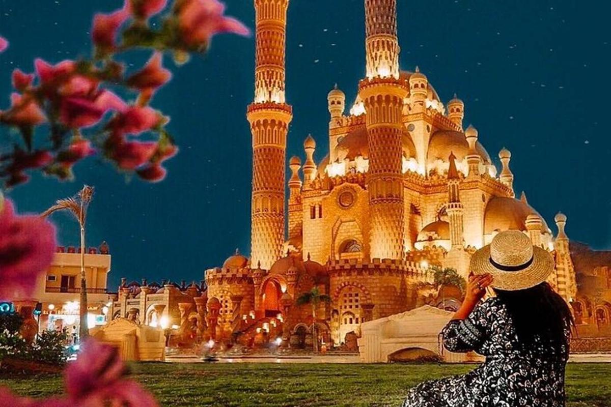 seorang wanita duduk di depan sebuah gedung di malam hari