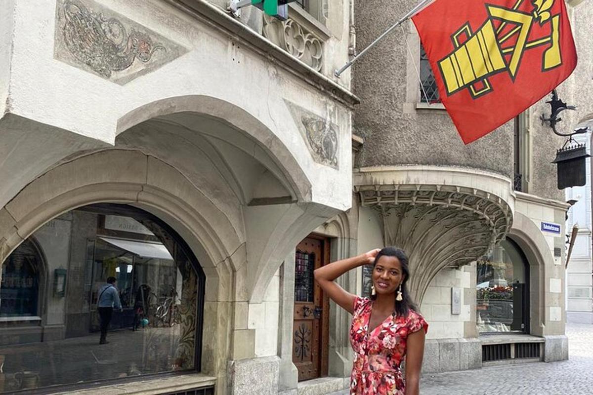 Una mujer parada frente a un edificio con una bandera.