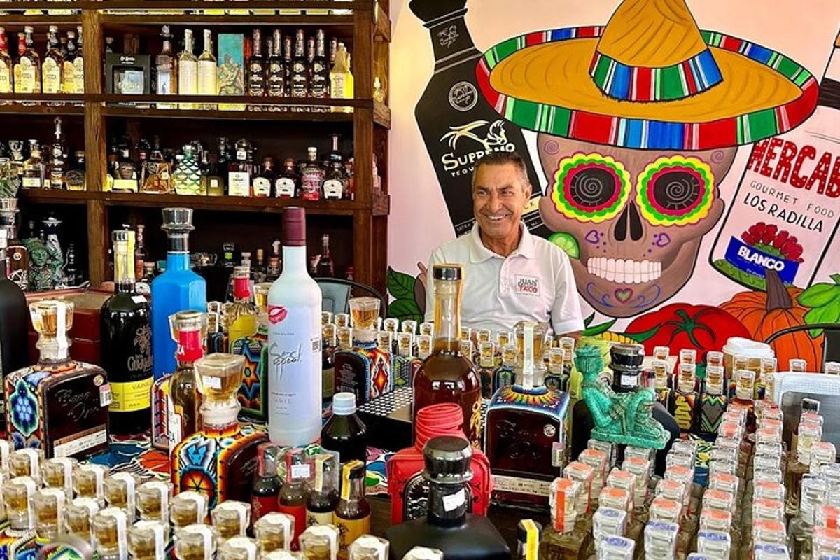 moški, ki stoji za mizo s steklenicami alkohola