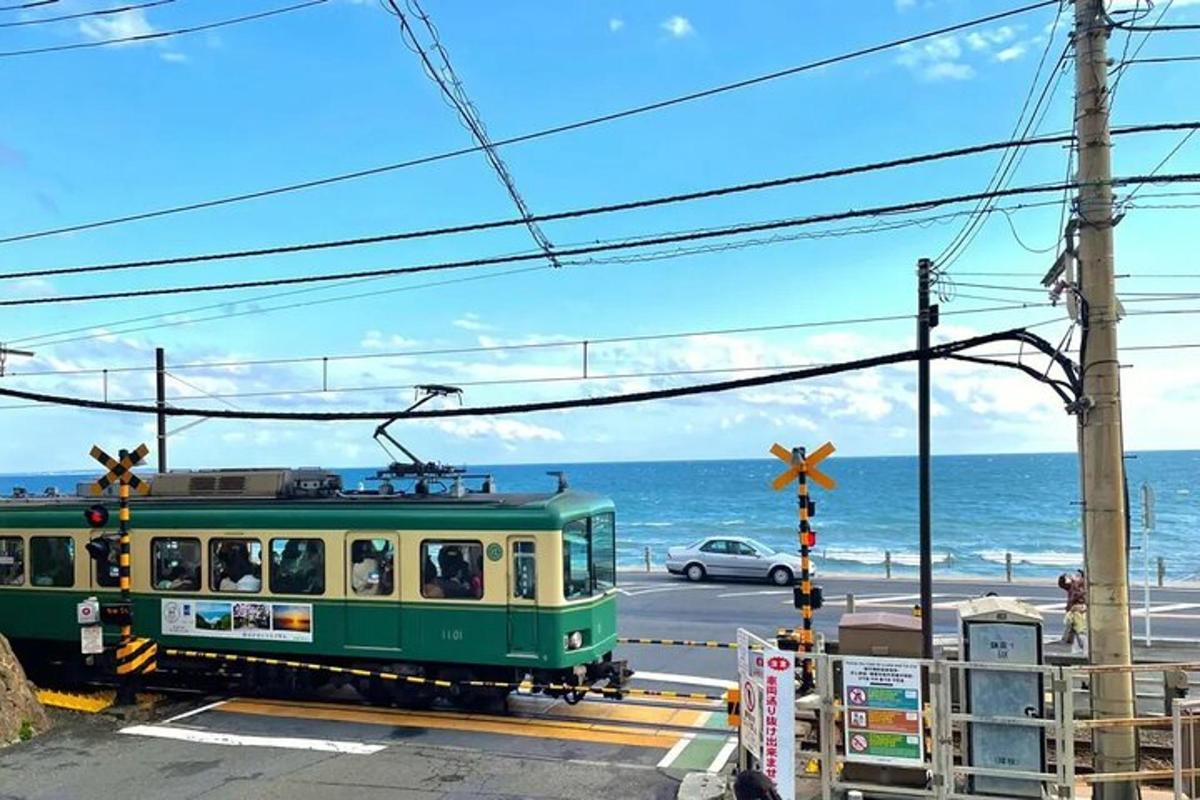 một chuyến tàu màu xanh lá cây chạy trên một con đường gần biển