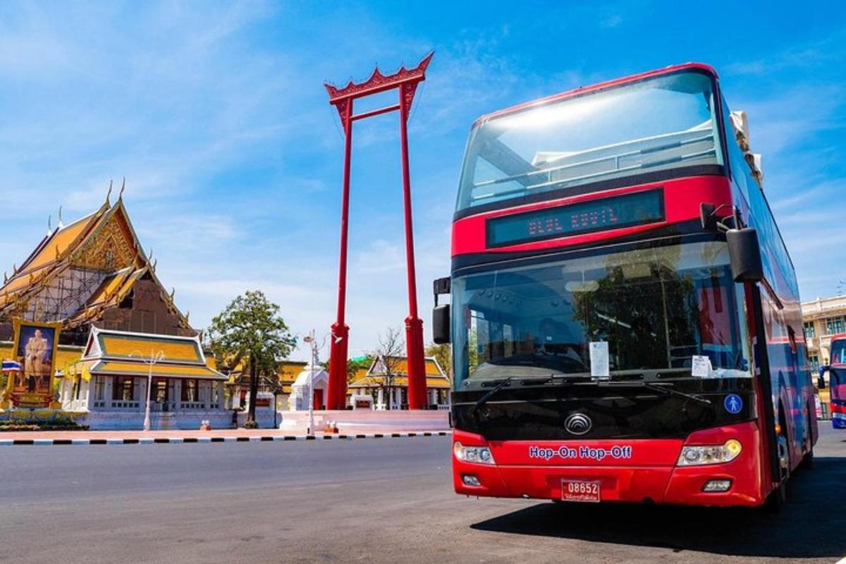 Un autobús rojo de dos pisos estacionado frente a un edificio