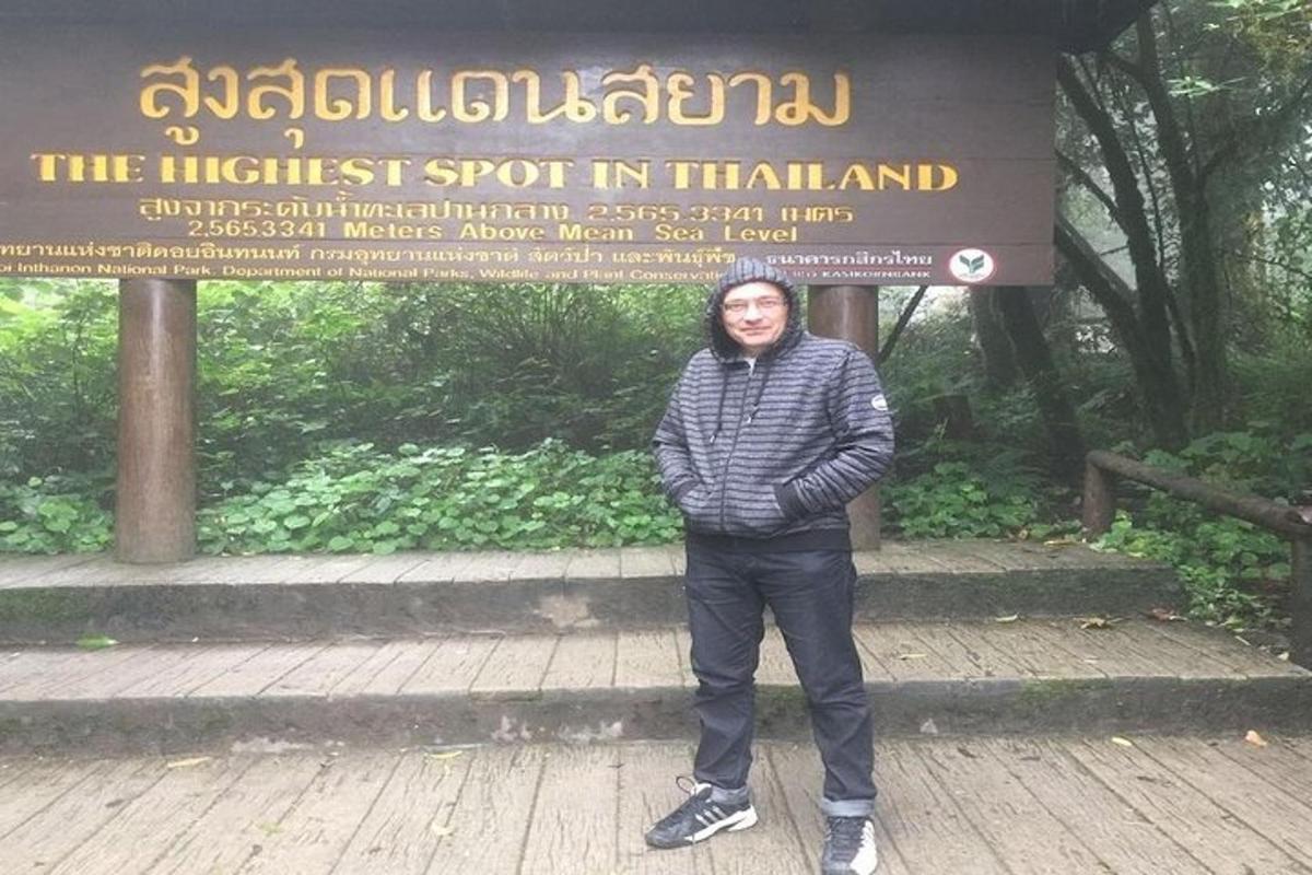 seorang lelaki berdiri di hadapan papan tanda