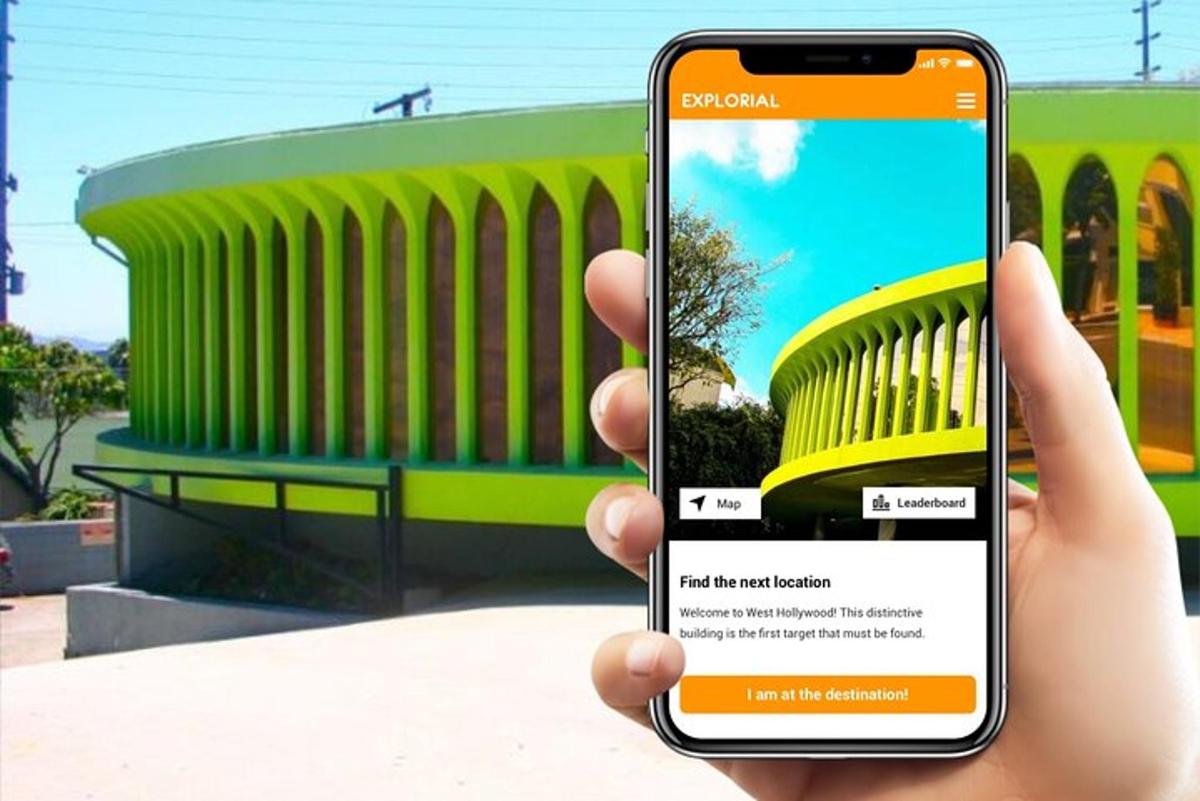 inimene, kes hoiab hoone ees mobiiltelefoni