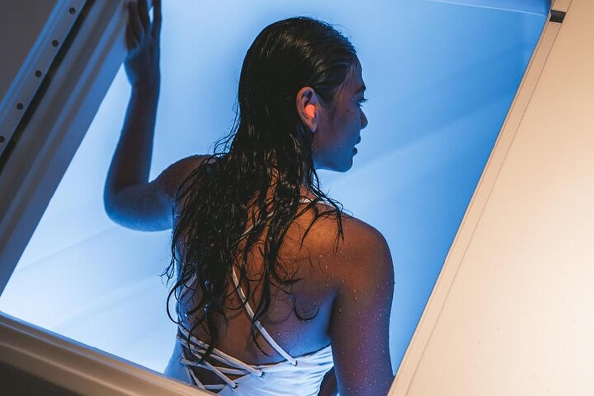 a woman standing in front of a window with a surfboard