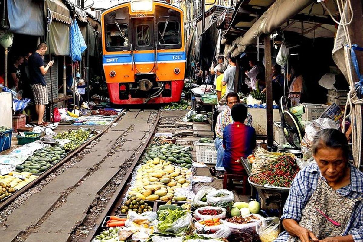 sebuah kereta api sedang melalui pasar dengan buah-buahan dan sayur-sayuran