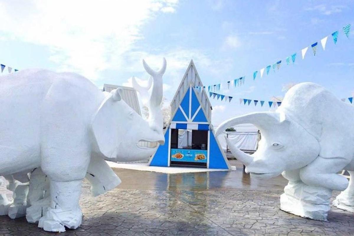 two white statues of elephants in front of a building