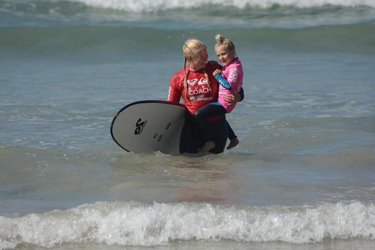 ženska in otrok sedita na deski za surfanje v oceanu