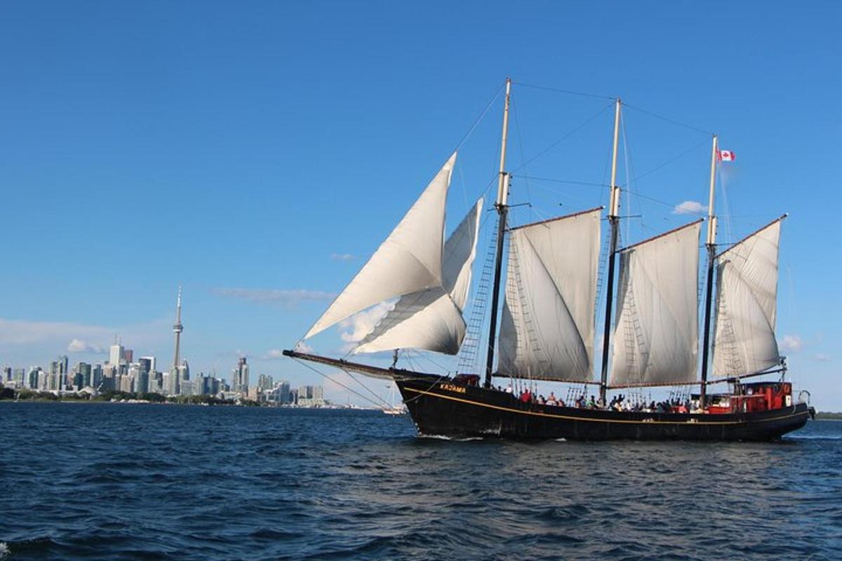 a large sail boat with white sails in the water