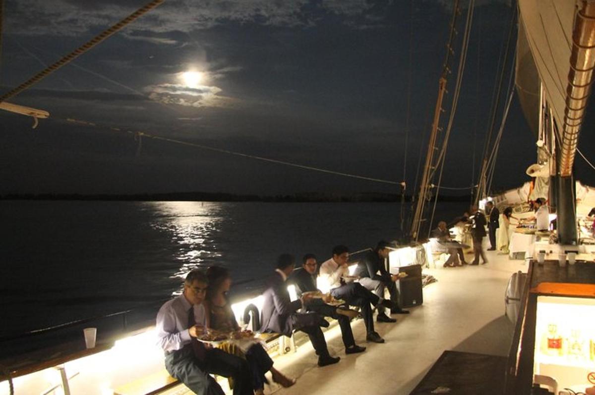 a group of people sitting on a boat at night