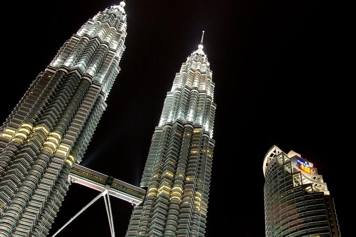 two tall buildings are lit up at night