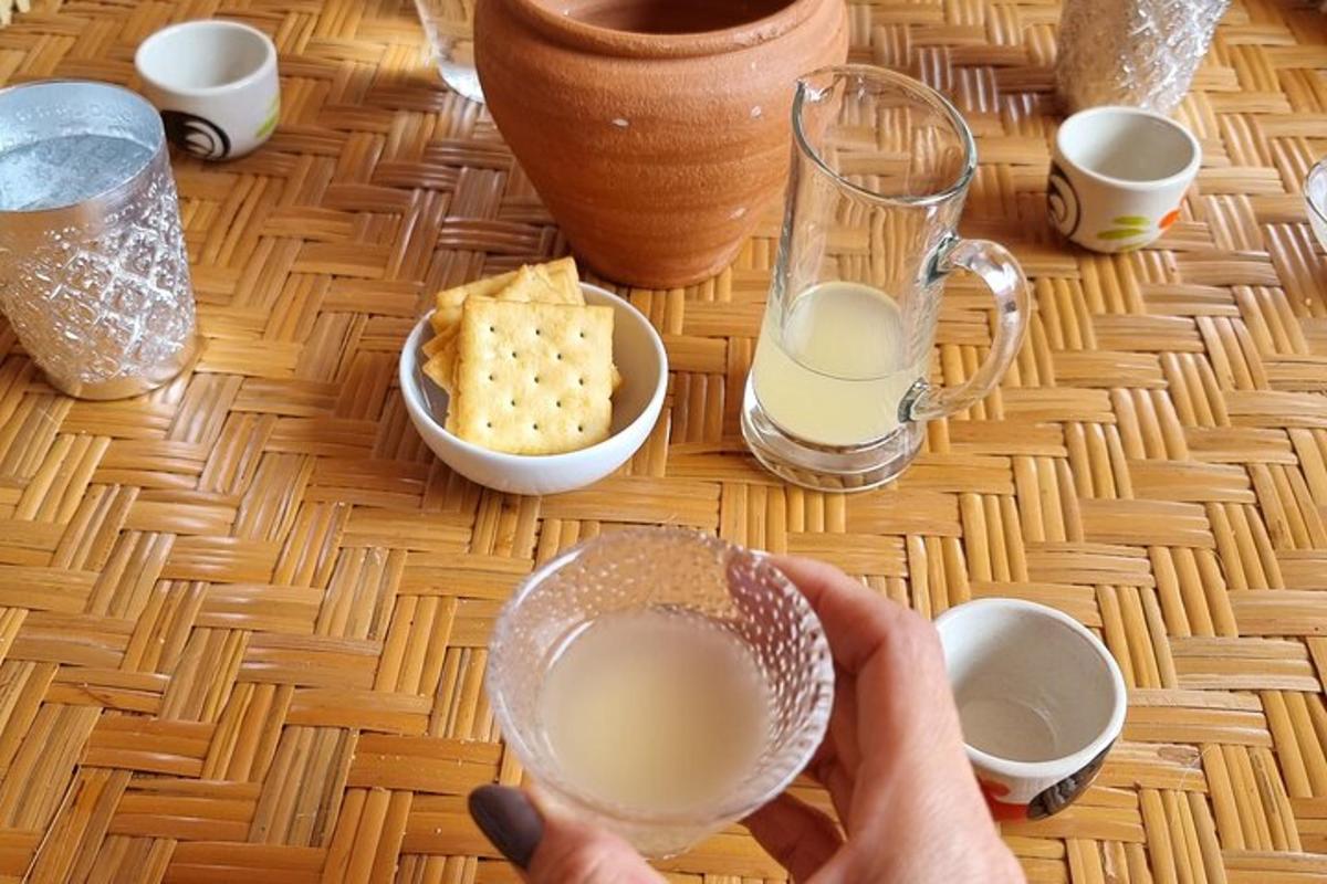 una persona sosteniendo un vaso de leche sobre una mesa
